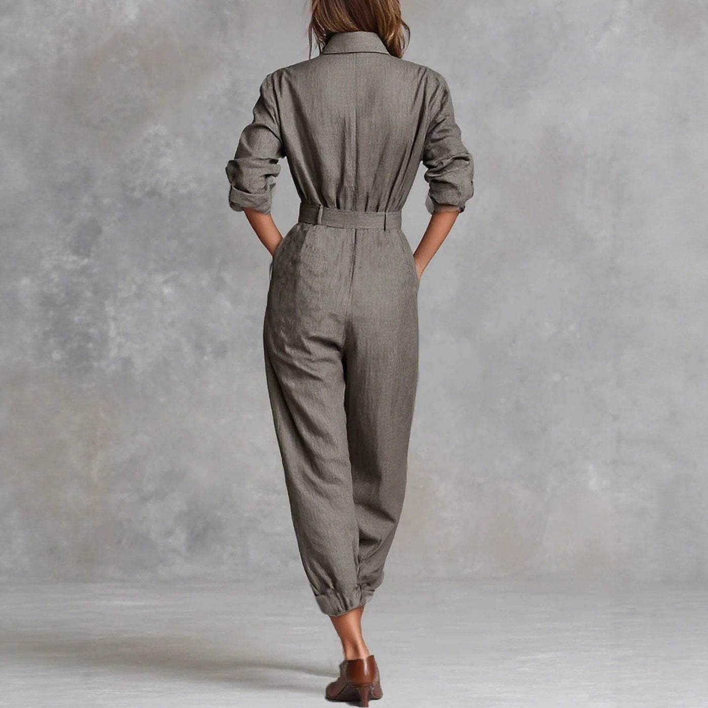 Woman wearing gray belted jumpsuit with rolled sleeves, back view, for everyday elegance and comfort