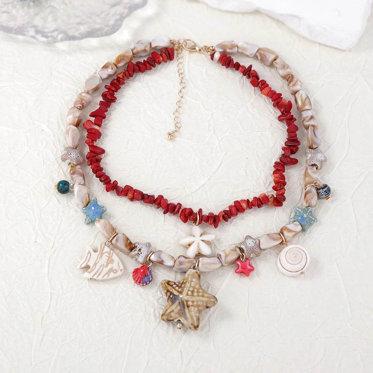 Layered beach necklace with red coral, shell beads, and starfish charms for coastal style
