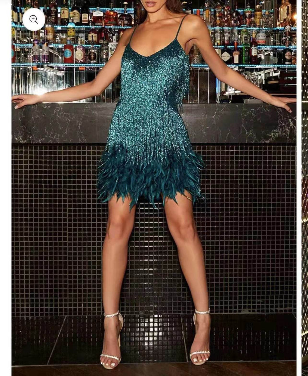 Teal sequin feather dress with strappy heels at bar