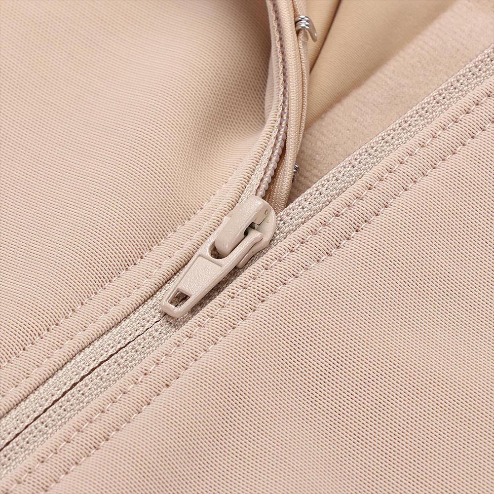 Close-up of a beige zipper on a fabric surface