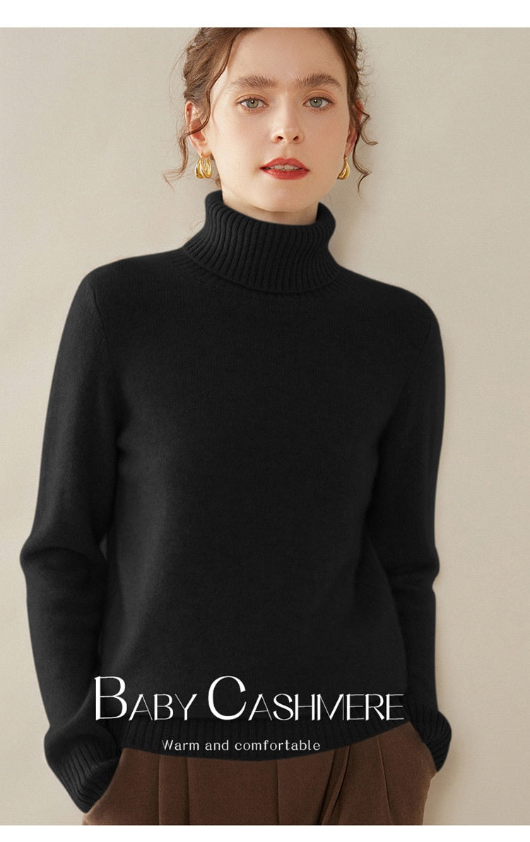 A woman wearing a black Laylace thick cashmere turtleneck sweater with long sleeves and a ribbed high neckline.