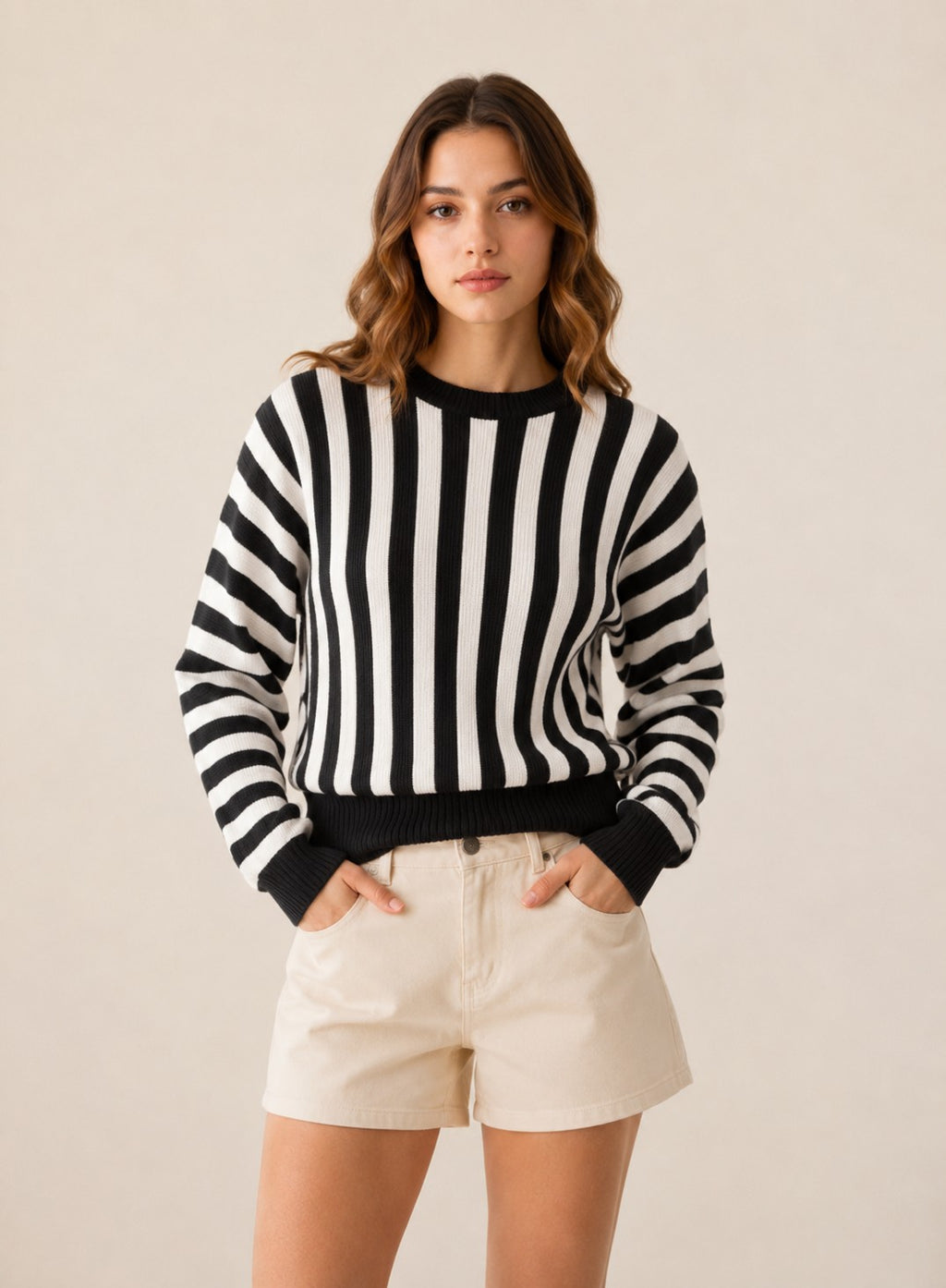 Laylace women's black and white vertical striped long-sleeve knit pullover sweater worn with beige shorts.