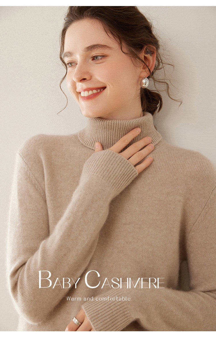 A woman wearing a soft camel Laylace thick cashmere turtleneck sweater with a cozy ribbed high neckline.