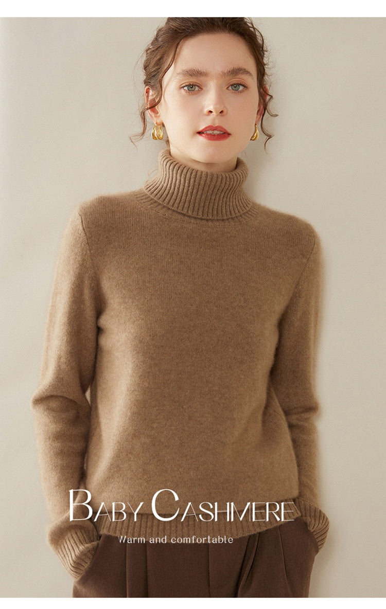 A woman wearing a Laylace thick camel cashmere turtleneck sweater with long sleeves and a ribbed high neckline.