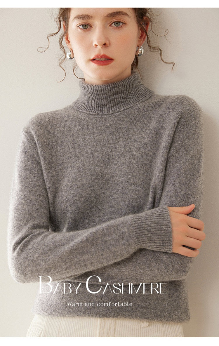 A woman wearing a Laylace gray thick cashmere turtleneck sweater with long sleeves and a ribbed collar.