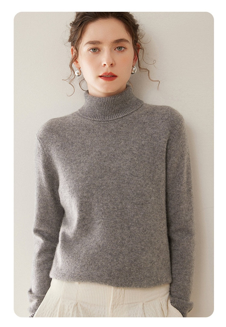 A woman wearing a Laylace gray thick cashmere turtleneck sweater with long sleeves and a soft knit texture.