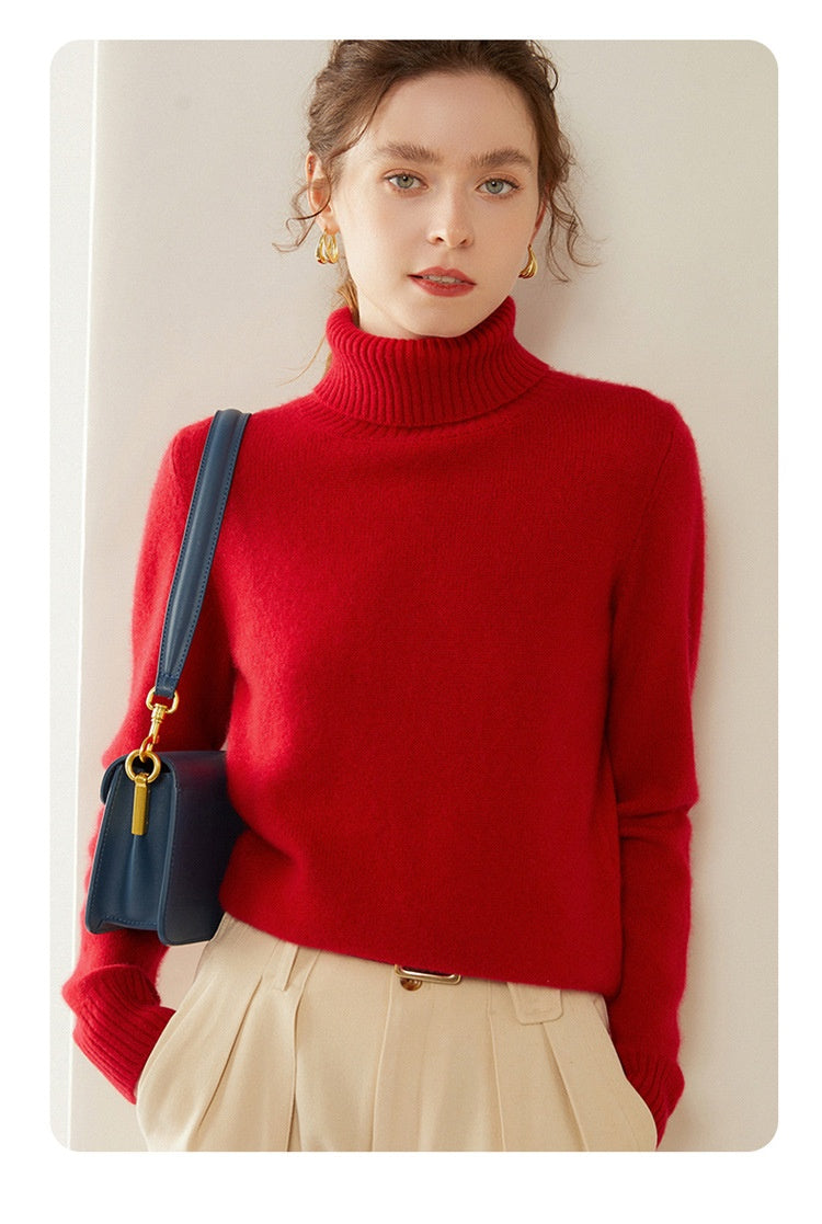 A woman wearing a Laylace red cashmere turtleneck sweater with long sleeves, paired with beige trousers and a bag.