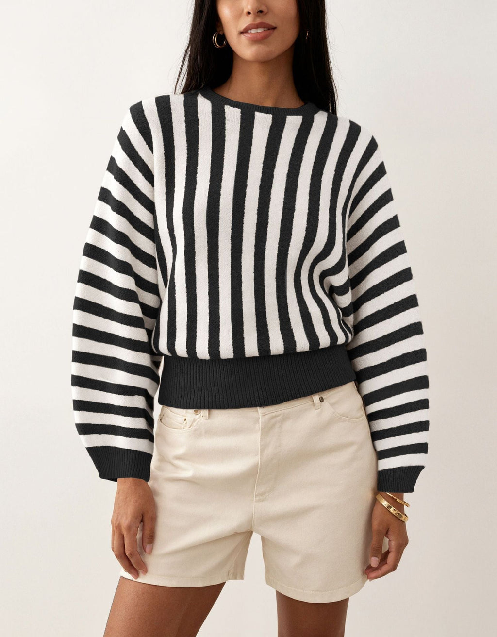 Laylace black and white vertical striped long-sleeve knit pullover sweater worn with beige shorts