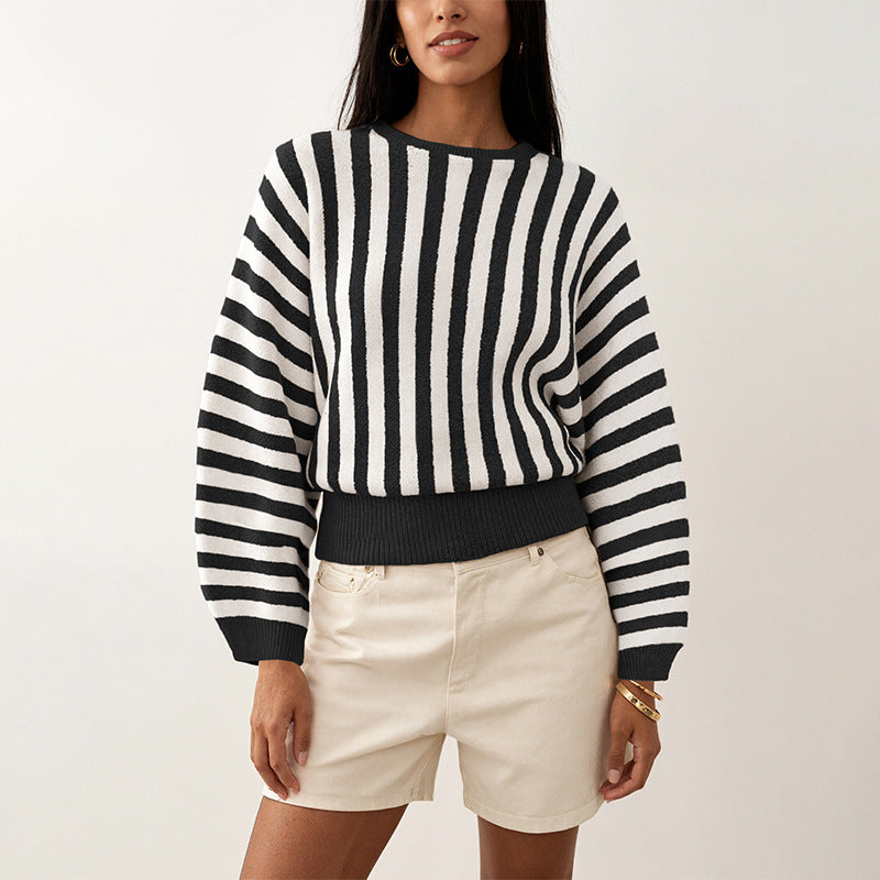 Laylace model wearing a black and white vertical striped long-sleeve knitted pullover sweater with a crew neckline.